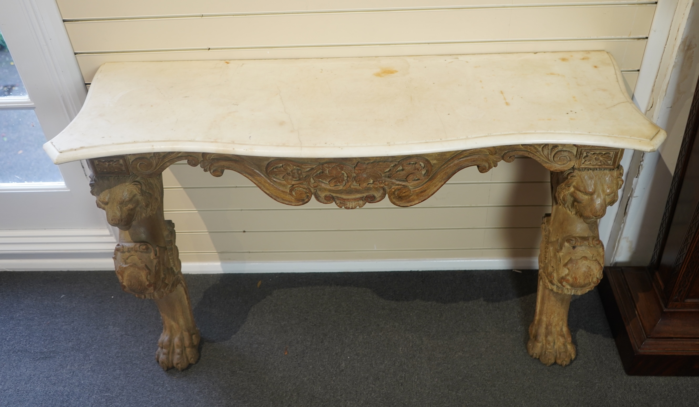 A 19th century Baroque style marble topped limed oak serpentine console table
